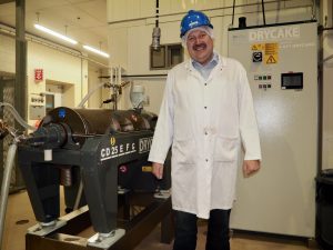Ken Gossen in front of decanter centrifuge at FPDC in Leduc, Alberta. Photo by Therese Kehler